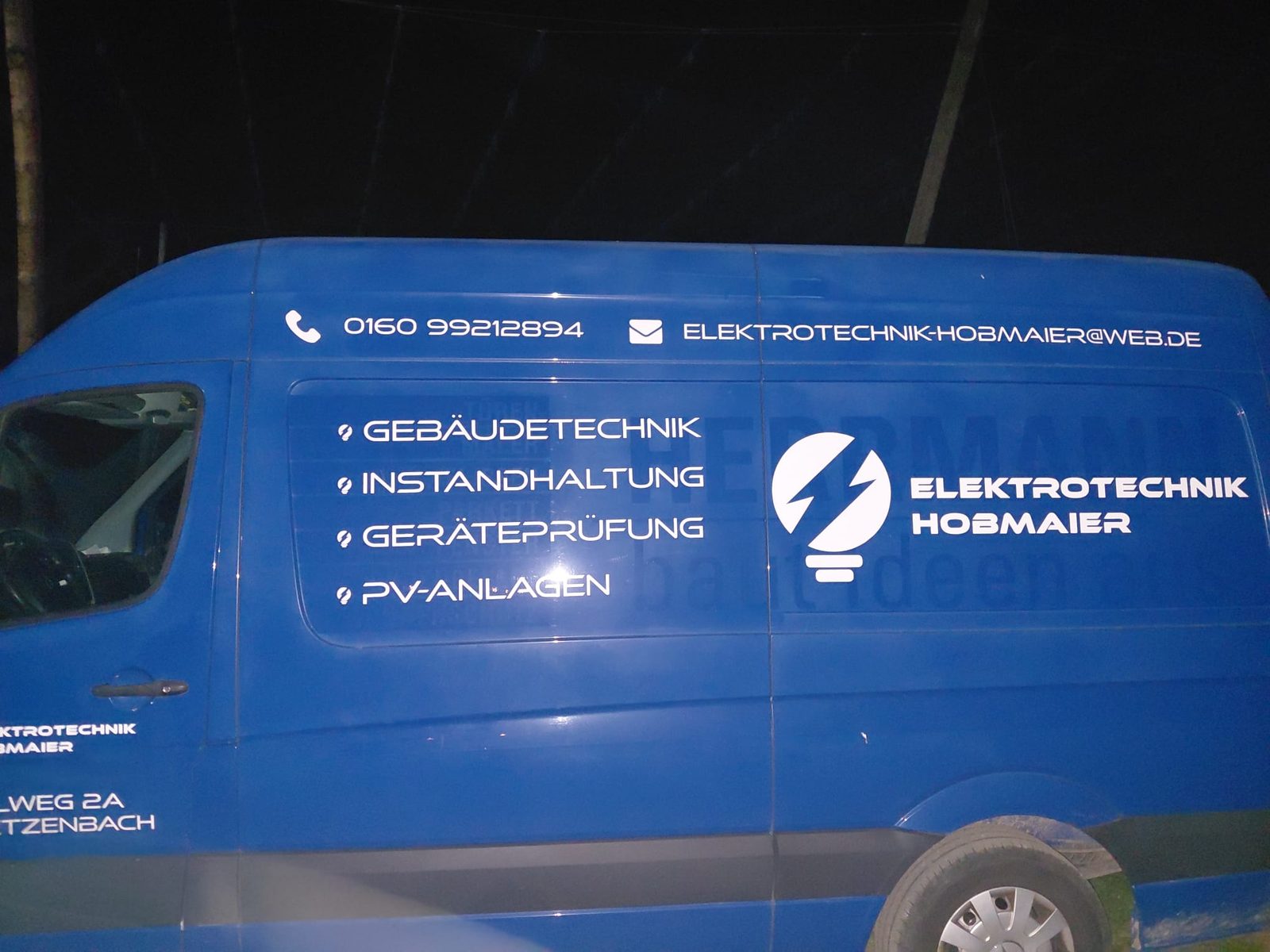 Blaues Firmenfahrzeug von Elektrotechnik Hobmaier mit Leistungsübersicht